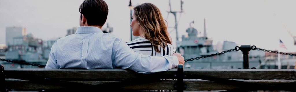 En mand og en kvinde sidder og kigger ud over en havn. Måske de kunne bruge en samtale med en sexolog?